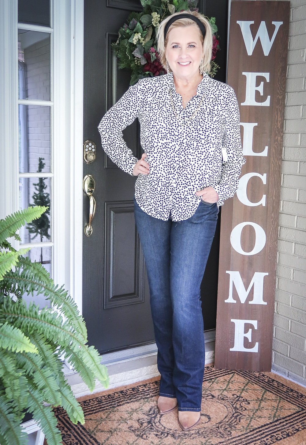 Fashion Blogger 50 Is Not Old is wearing a dotted blouse, bootcut jeans, and ankle boots for fall