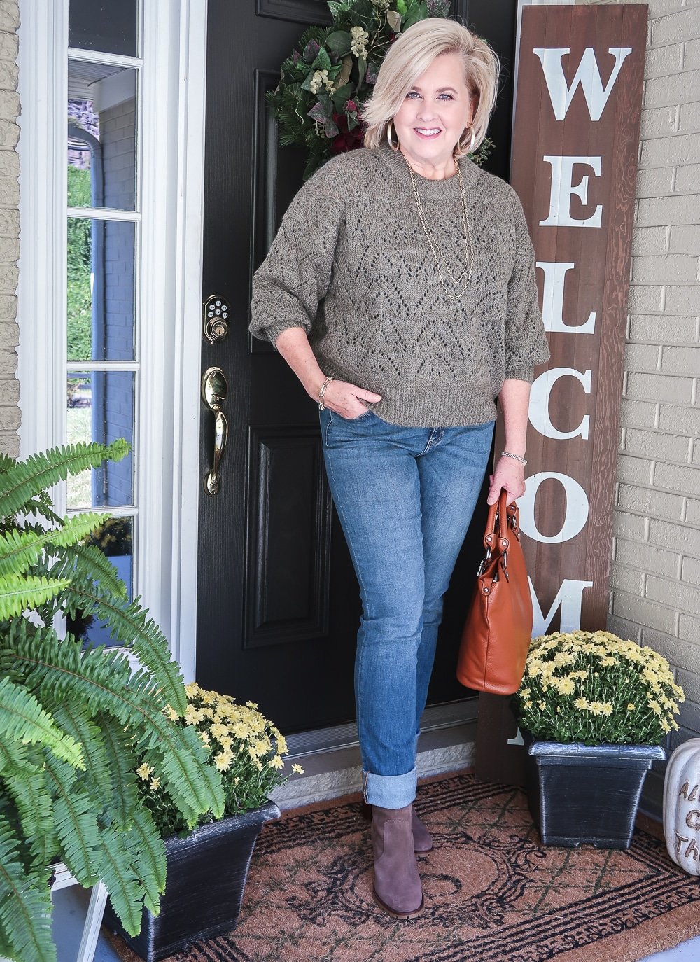 Fashion Blogger 50 Is Not Old is wearing a Pointelle olive colored sweater with cuffed jeans and Tory Burch ankle boots