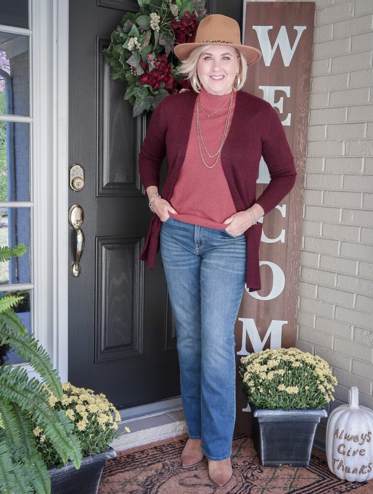 Fashion Blogger 50 Is Not Old is wearing a brown Fedora with a maroon cardigan, a rose colored sweater and blue jeans