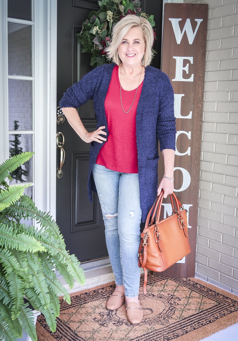 Fashion Blogger 50 Is Not Old is weekend ready in her burgundy t-shirt, distressed jeans, chunky knit cardigan, and leather handbag