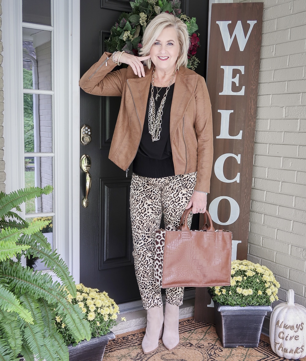 Fashion Blogger 50 Is Not Old is over 40 and still looks fabulous in a black top and cheetah print jeans with the Faux-Leather Moto Jacket from Chicos