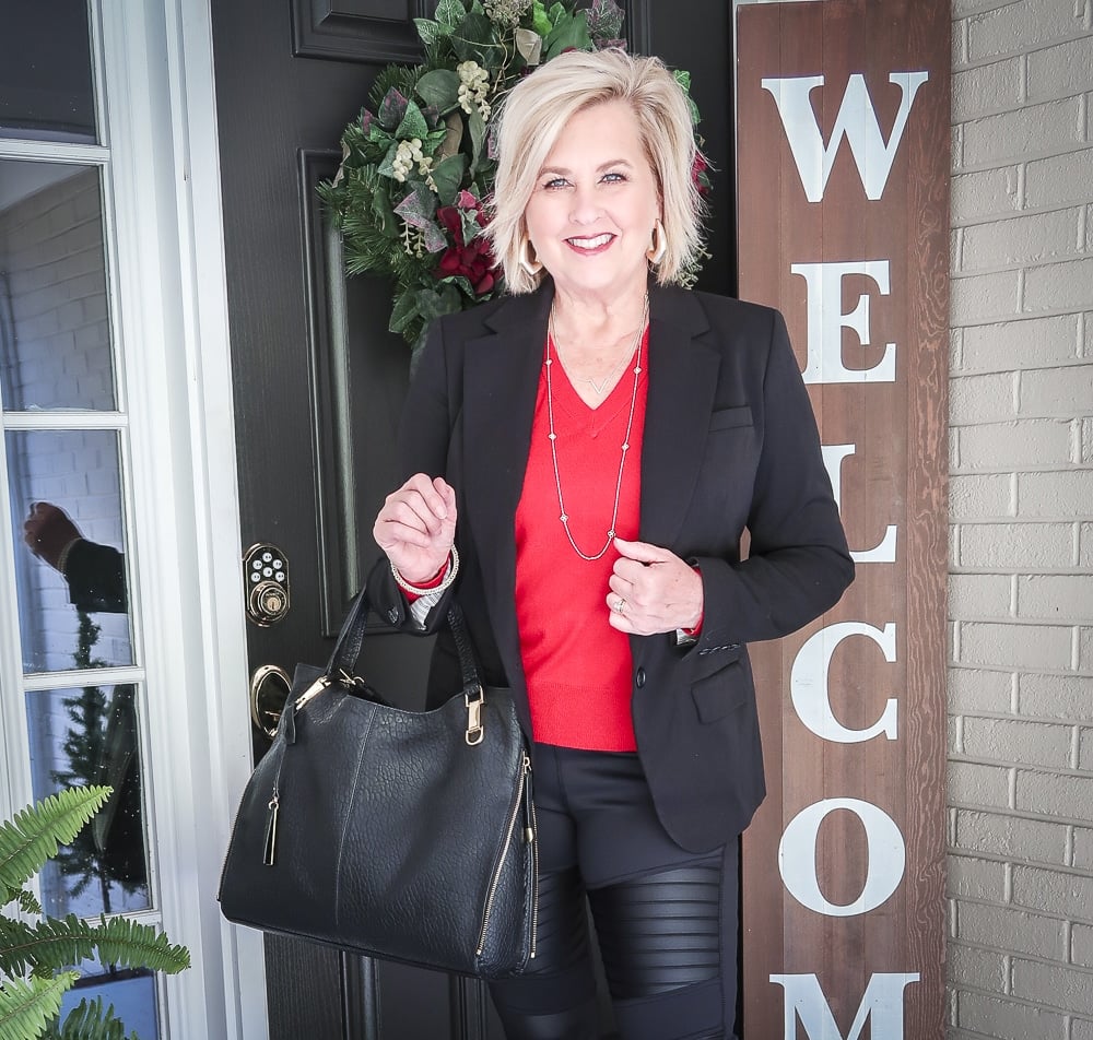Fashion Blogger 50 Is Not Old is looking modern and edgy in this pair of black faux leather moto leggings and a red sweater, red pumps, and a black handbag