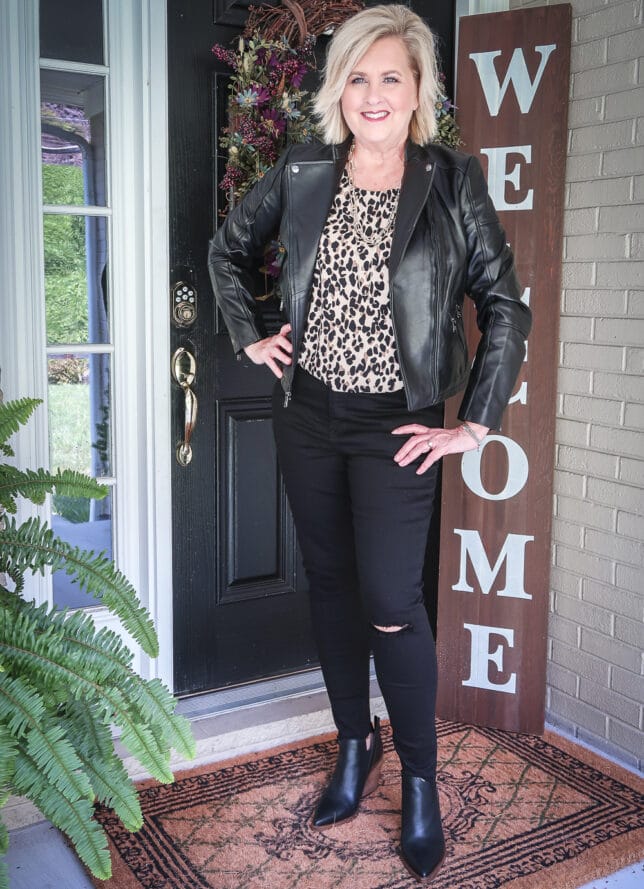 Fashion Blogger 50 Is Not Old is wearing a leopard print top with a pair of black distressed jeans, and a black leather moto jacket