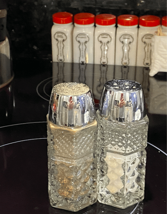 salt and pepper shakers sitting on a stove