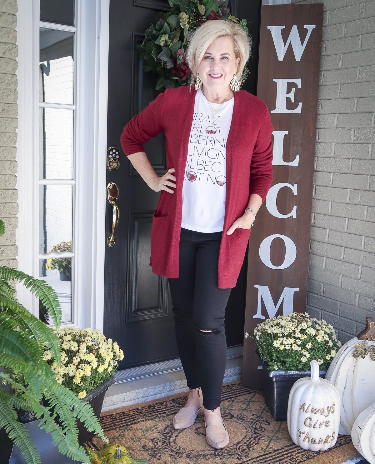 Fashion Blogger 50 Is Not Old is wearing a long burgundy cardigan, a wine t-shirt, and black skinny jeans