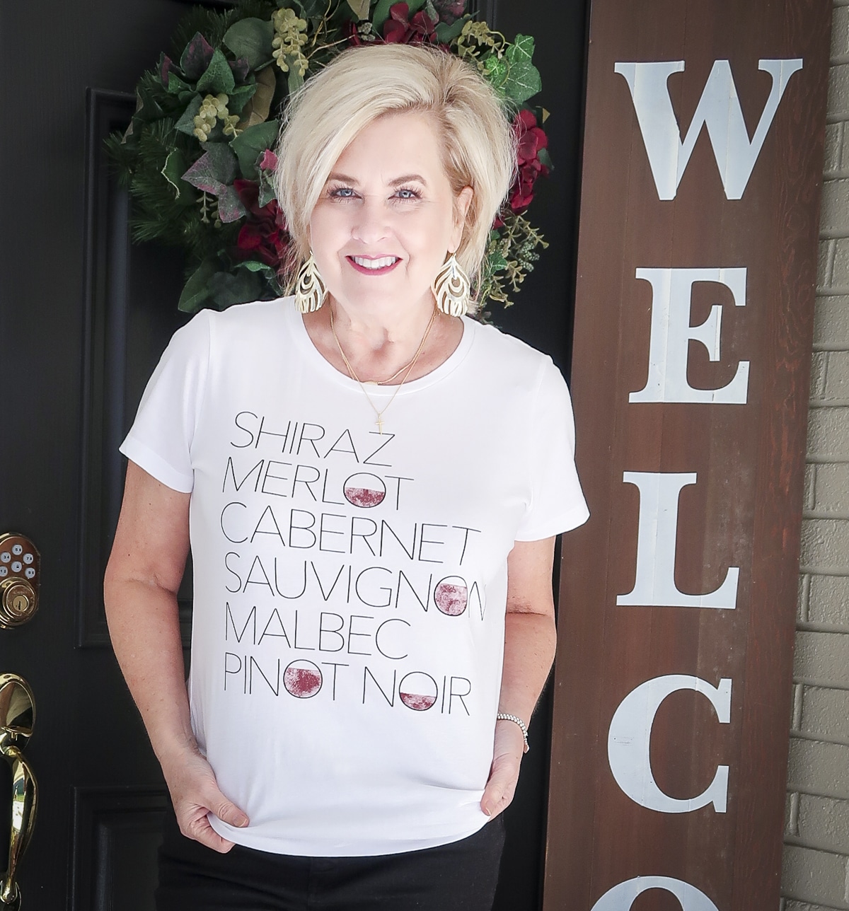 Fashion Blogger 50 Is Not Old is wearing a wine t-shirt with gold earrings