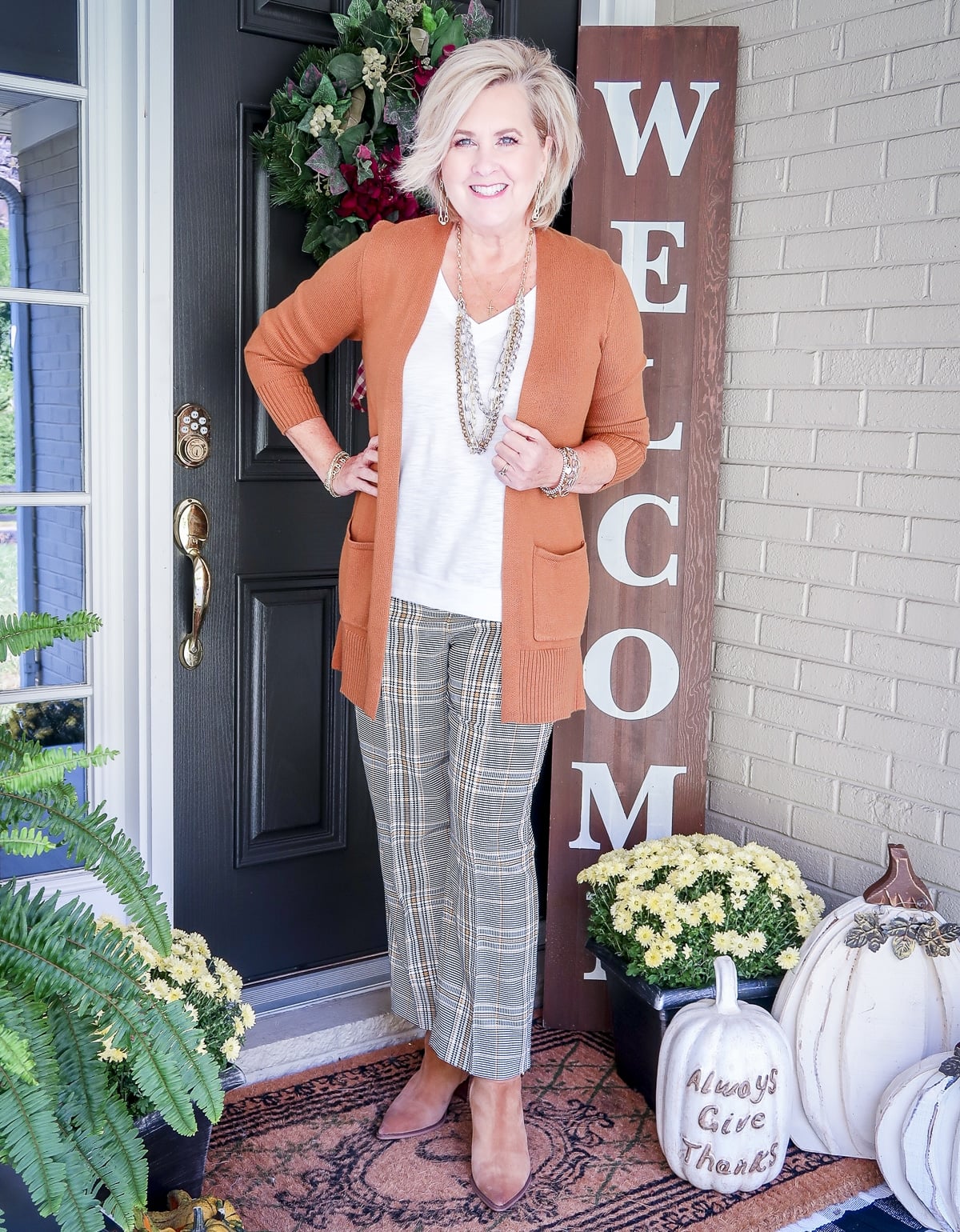 Fashion Blogger 50 Is Not Old is wearing a white tank with a caramel cardigan, plaid ankle pants, Sam Edelman ankle boots, and jewelry accessories by Kendra Scott
