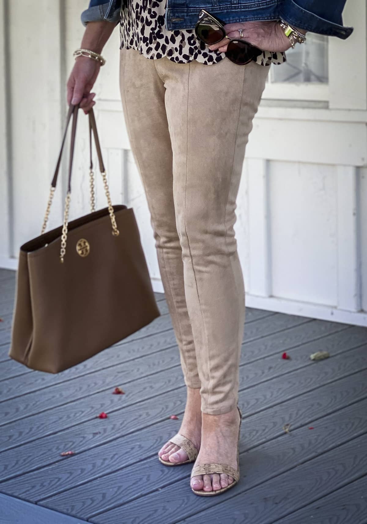 Fashion Blogger 50 Is Not Old is wearing a neutral outfit consisting of suede leggings and a Tory Burch handbag