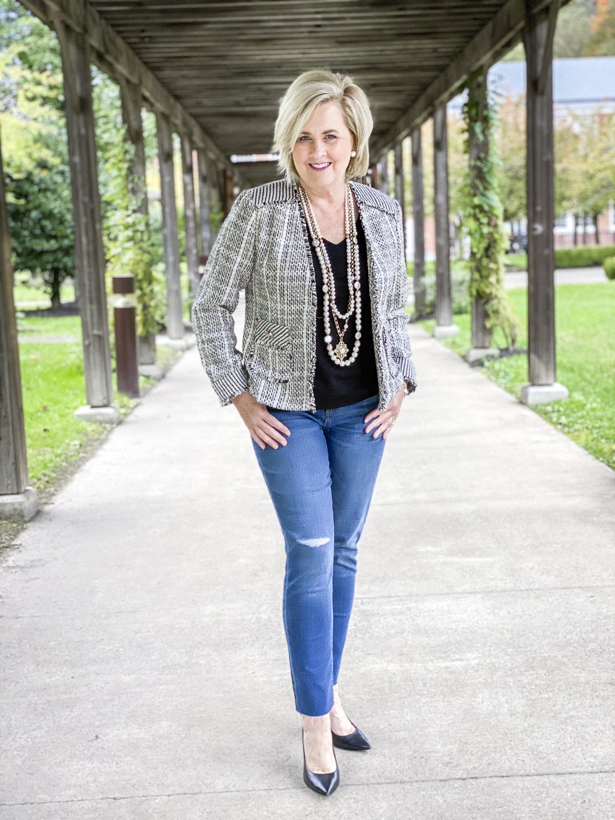 Fashion Blogger 50 Is Not Old is looking sassy in a classic tweed blazer, distressed jeans, and pearls