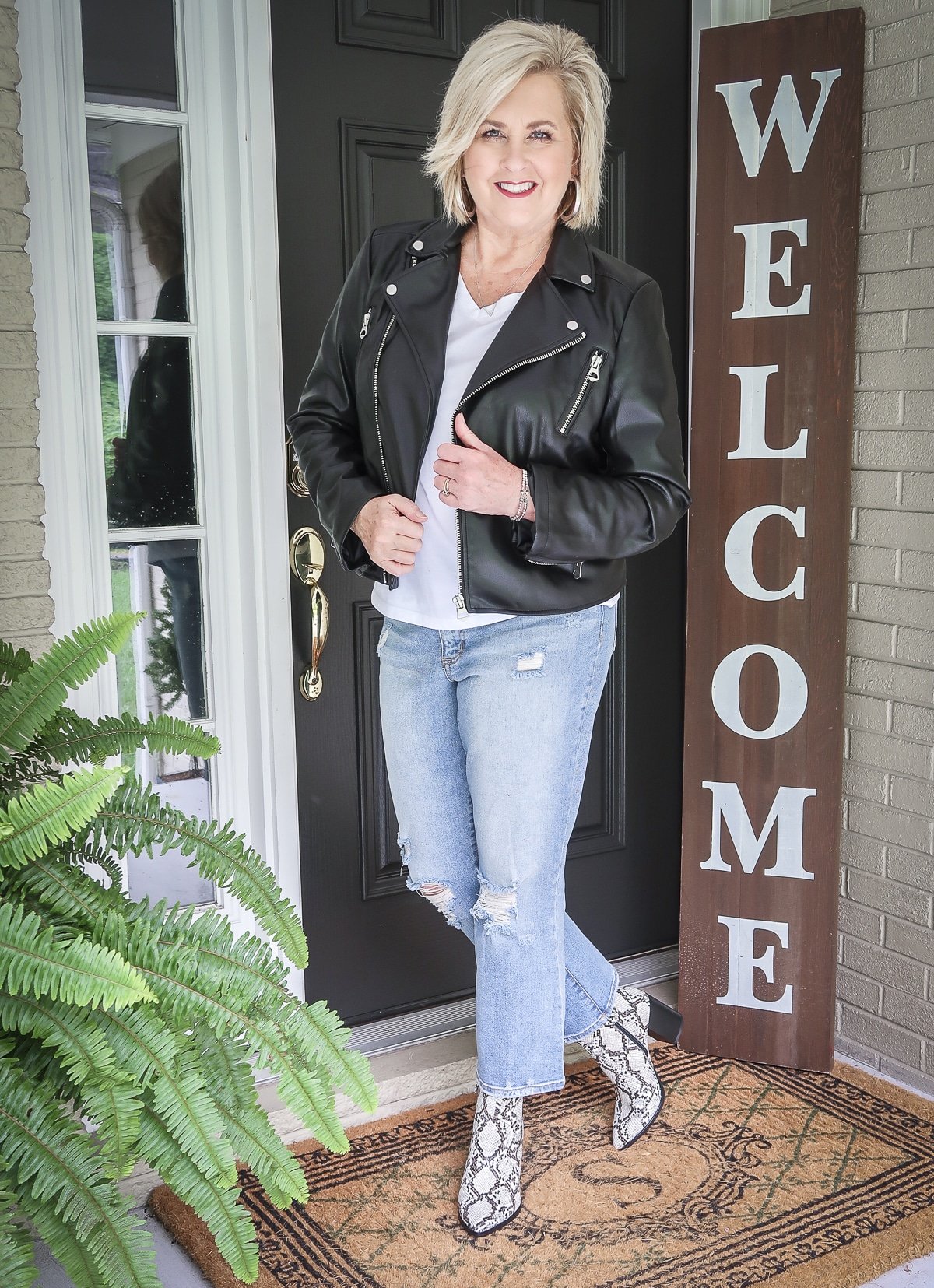 Fashion Blogger 50 Is Not Old keeps looking young with a moto jacket, distressed jeans, and snakeskin boots