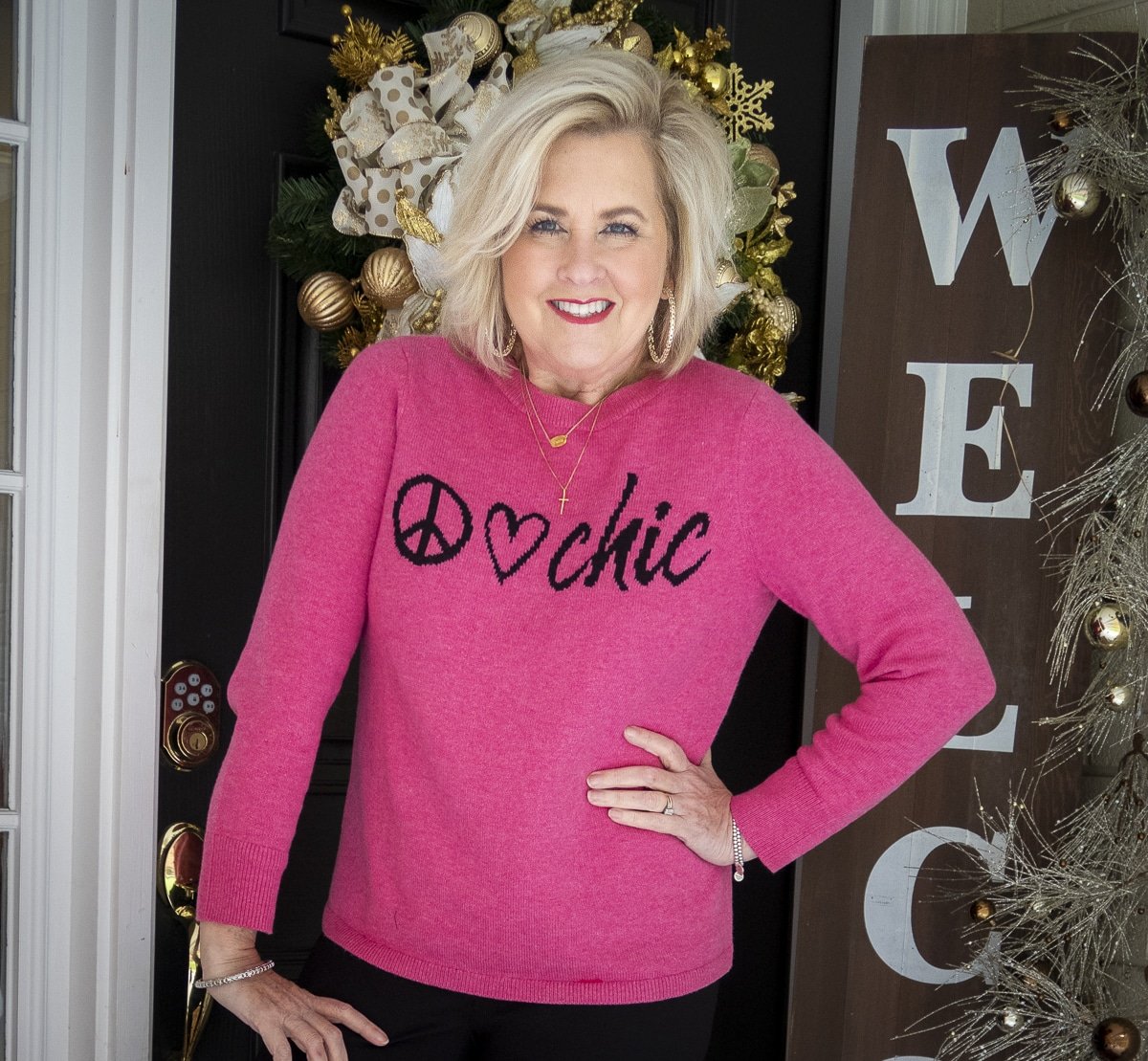 Fashion Blogger 50 Is Not Old is wearing a bright pink sweater from Chico's with graphic writing