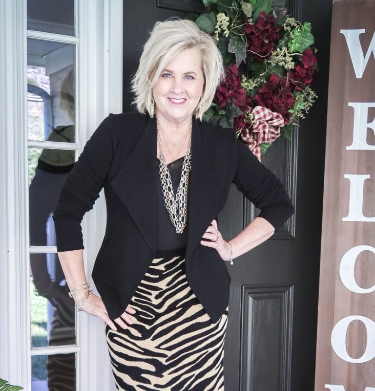 Fashion Blogger 50 Is Not Old is wearing an animal print sweater skirt with a black camisole and blazer