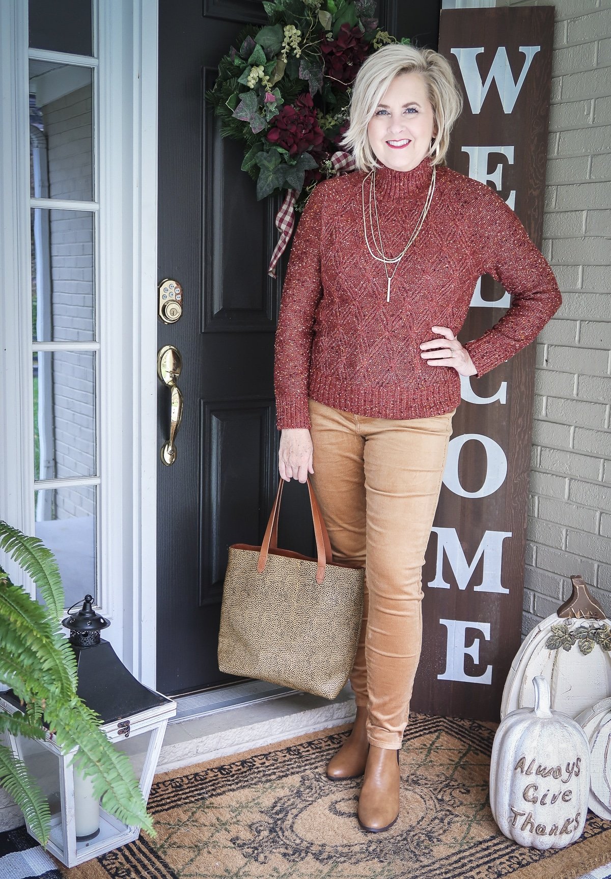 Fashion Blogger 50 Is Not Old is wearing a gorgeous rust turtleneck sweater with gold jewelry and caramel corduroy skinny pants and caramel colored ankle boots