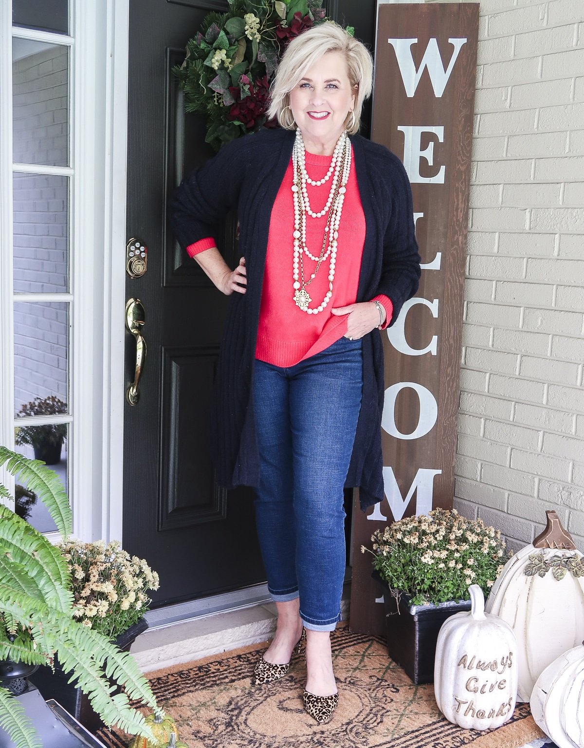 Fashion Blogger 50 Is Not Old is wearing a bright pink sweater with ankle jeans and leopard print heels