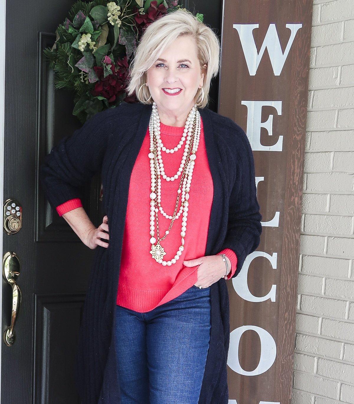 Fashion Blogger 50 Is Not Old is wearing a bright pink sweater lots of pearls necklaces