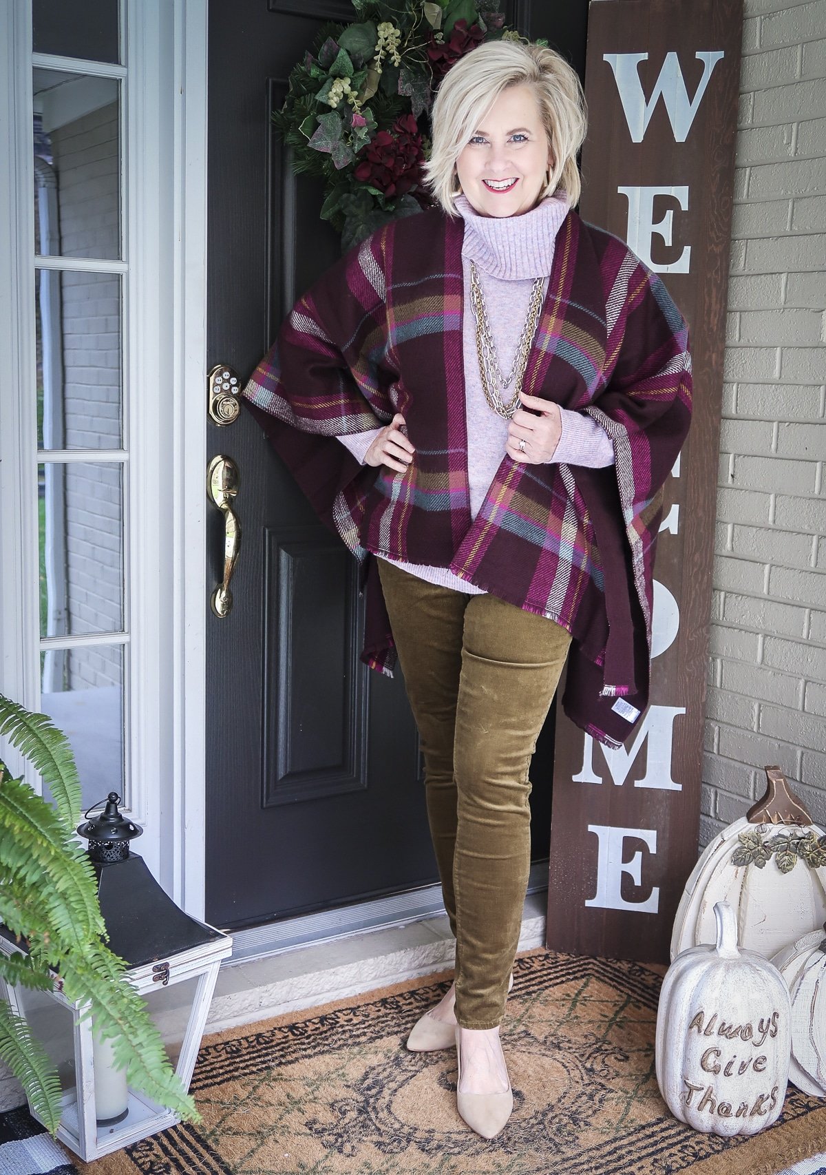 Fashion Blogger, 50 Is Not Old, is Thanksgiving ready with this colorful plaid wrap, lilac cowl neck sweater, gold jewelry, and olive corduroy skinny pants