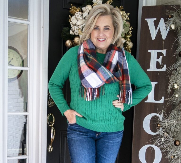 Fashion Blogger 50 Is Not Old is wearing a blanket scarf and green cable-knit sweater.
