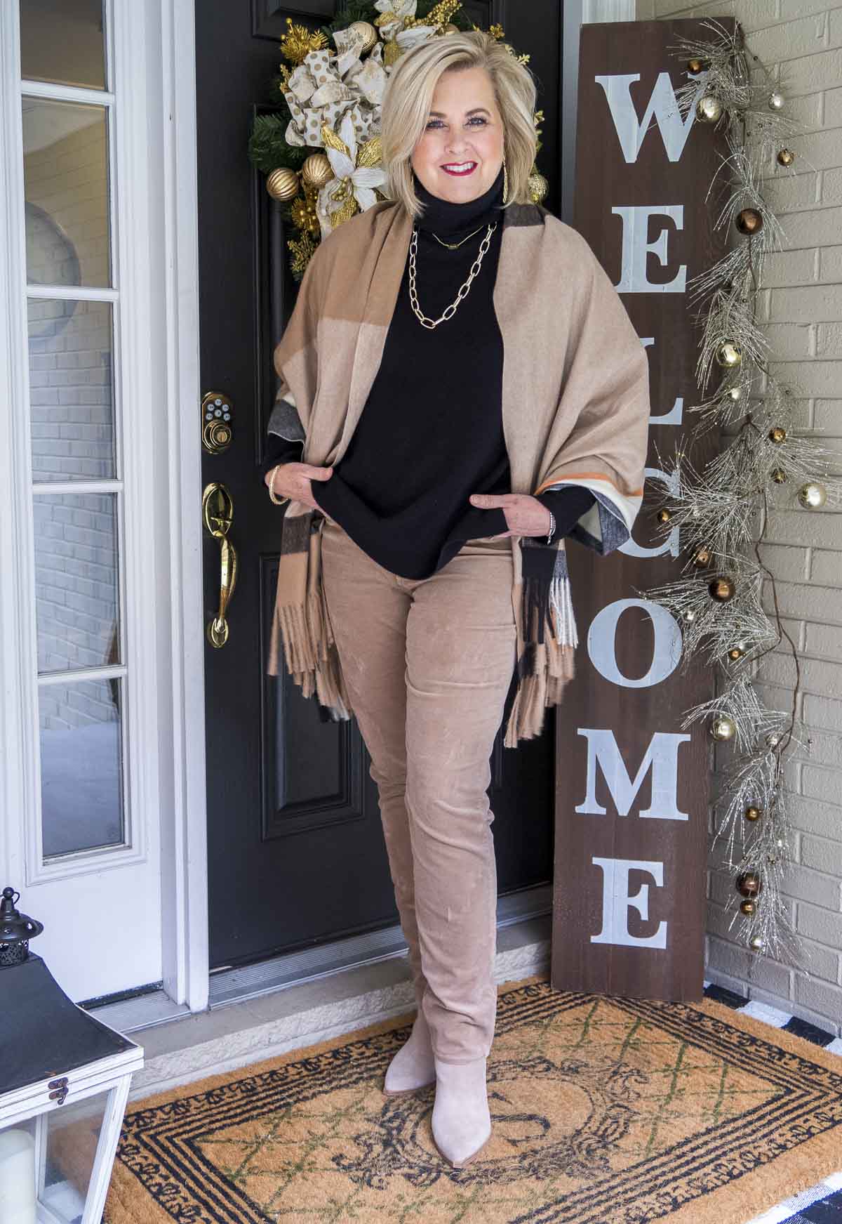 Fashion Blogger 50 Is Not Old is styling a simple and classic look with a black cashmere turtleneck sweater, gold jewelry, and taupe corduroy pants