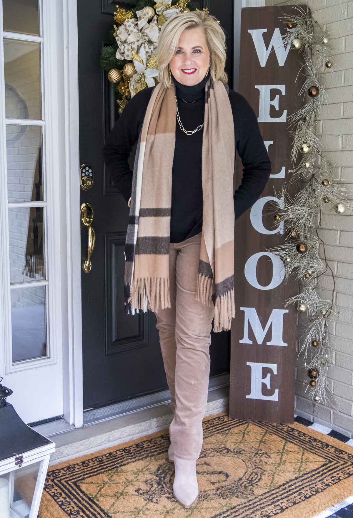 Fashion Blogger 50 Is Not Old is styling a simple black turtleneck sweater and taupe corduroy pants with a plaid scarf