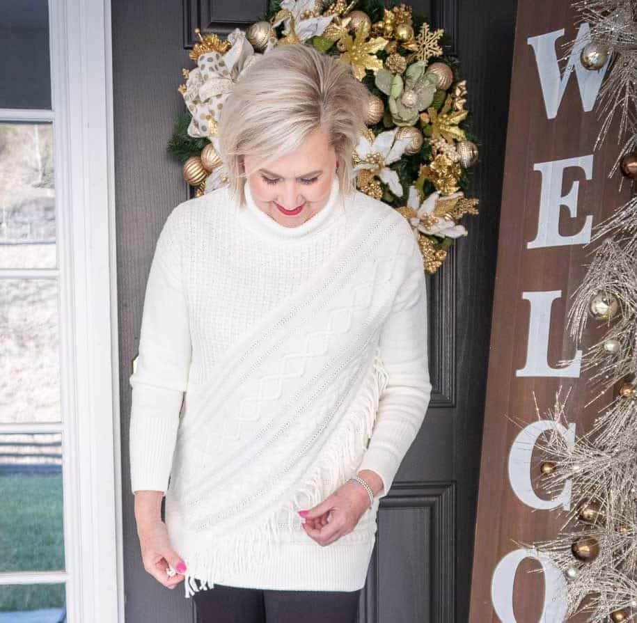 Fashion Blogger 50 Is Not Old is looking at her Ecru sweater with unique details including fringe