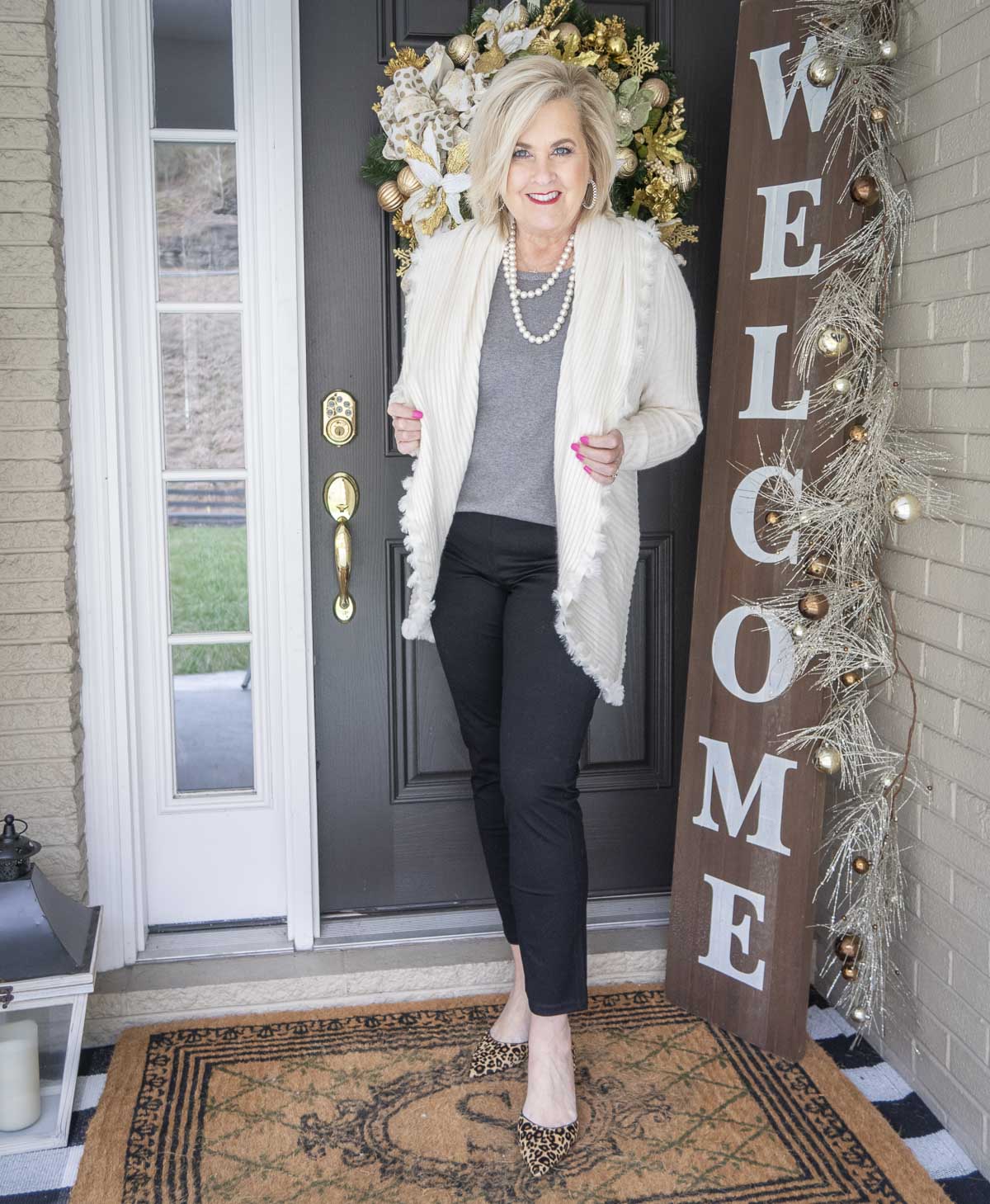 Fashion Blogger 50 Is Not Old is wearing a gray tank with an Ecru colored cocoon cardigan with a large collar, black girlfriend jeans, and leopard print shoes