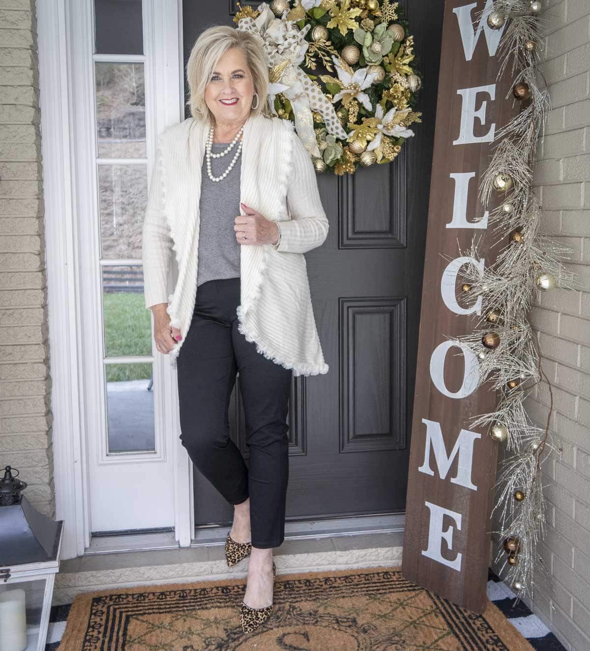 Fashion Blogger 50 Is Not Old is wearing a gray tank with an Ecru colored cocoon cardigan with a large collar, black girlfriend jeans, and leopard print heels