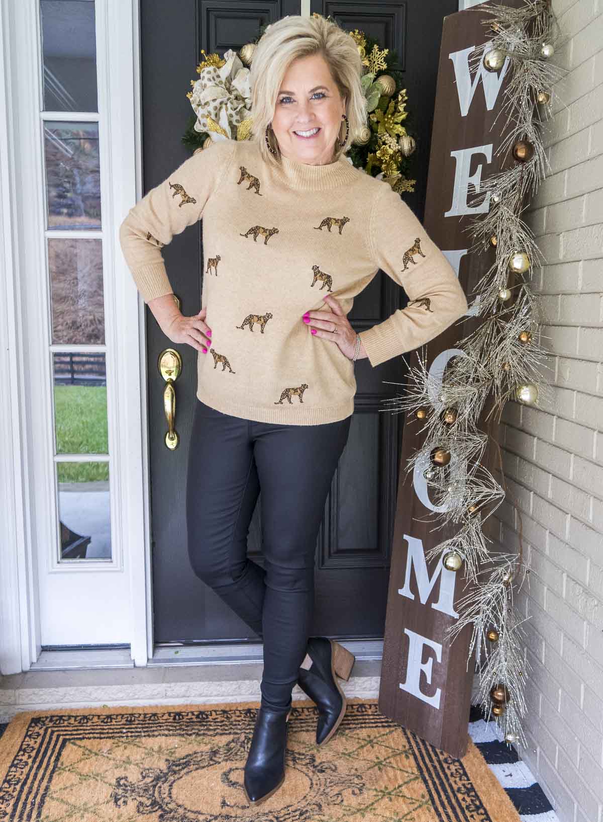 Fashion Blogger 50 Is Not Old is wearing a luxurious cashmere sweater with cheetahs embroidered on it, a pair of black coated jeans, and black ankle boots