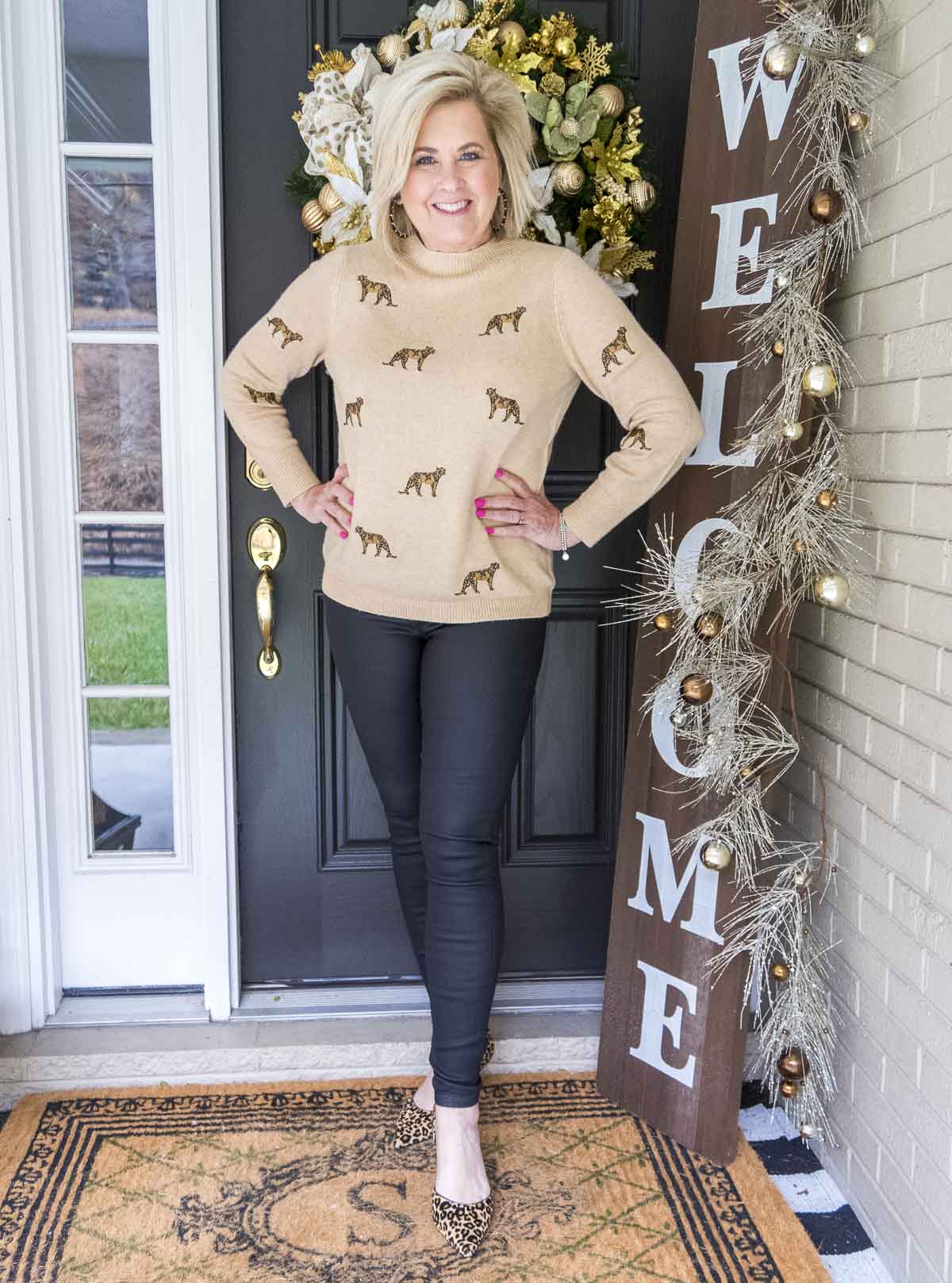 Fashion Blogger 50 Is Not Old is wearing a luxurious cashmere sweater with cheetahs embroidered on it, and a pair of black coated jeans