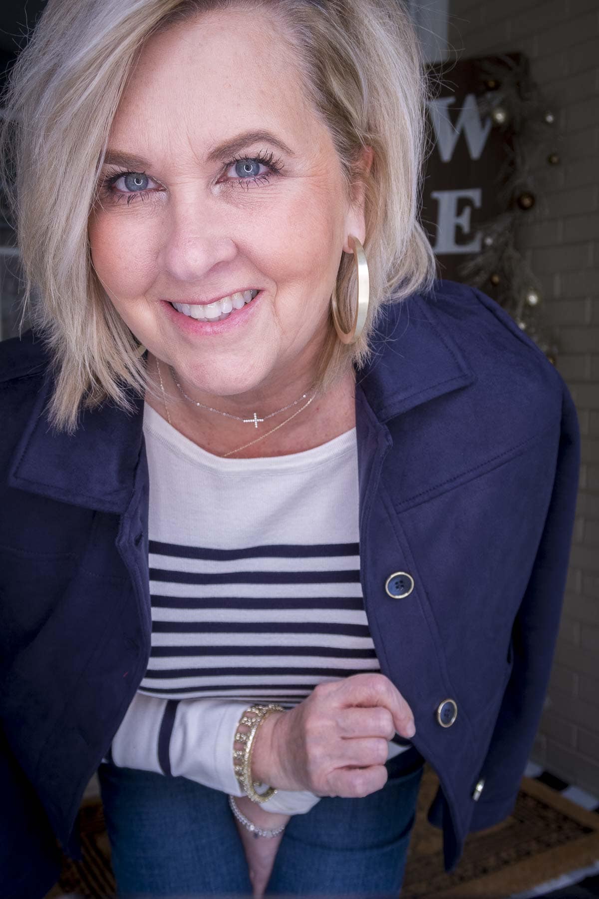 Fashion Blogger 50 Is Not Old is wearing a striped sweater with a navy faux suede jacket with gold jewelry