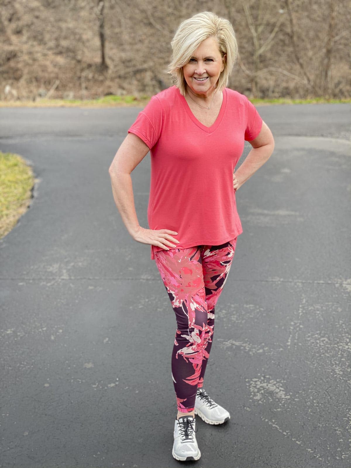 Fashion Blogger 50 Is Not Old is getting moving in a pink top with printed leggings, and going walking in a pair of On Cloud training shoes