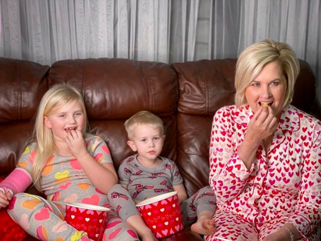 Fashion Blogger 50 Is Not Old is creating memories with her grandchildren in their PJs by watching a movie and eating popcorn