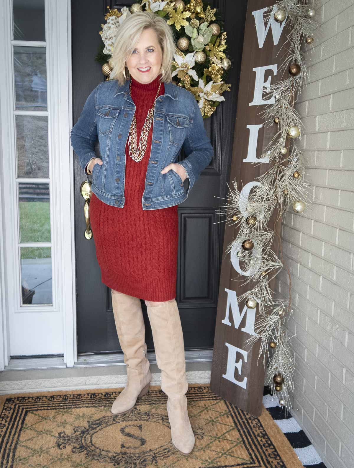 Fashion Blogger 50 Is Not Old is wearing a red sweater dress from Ann Taylor, a denim jacket from Talbots, and tall knee boots