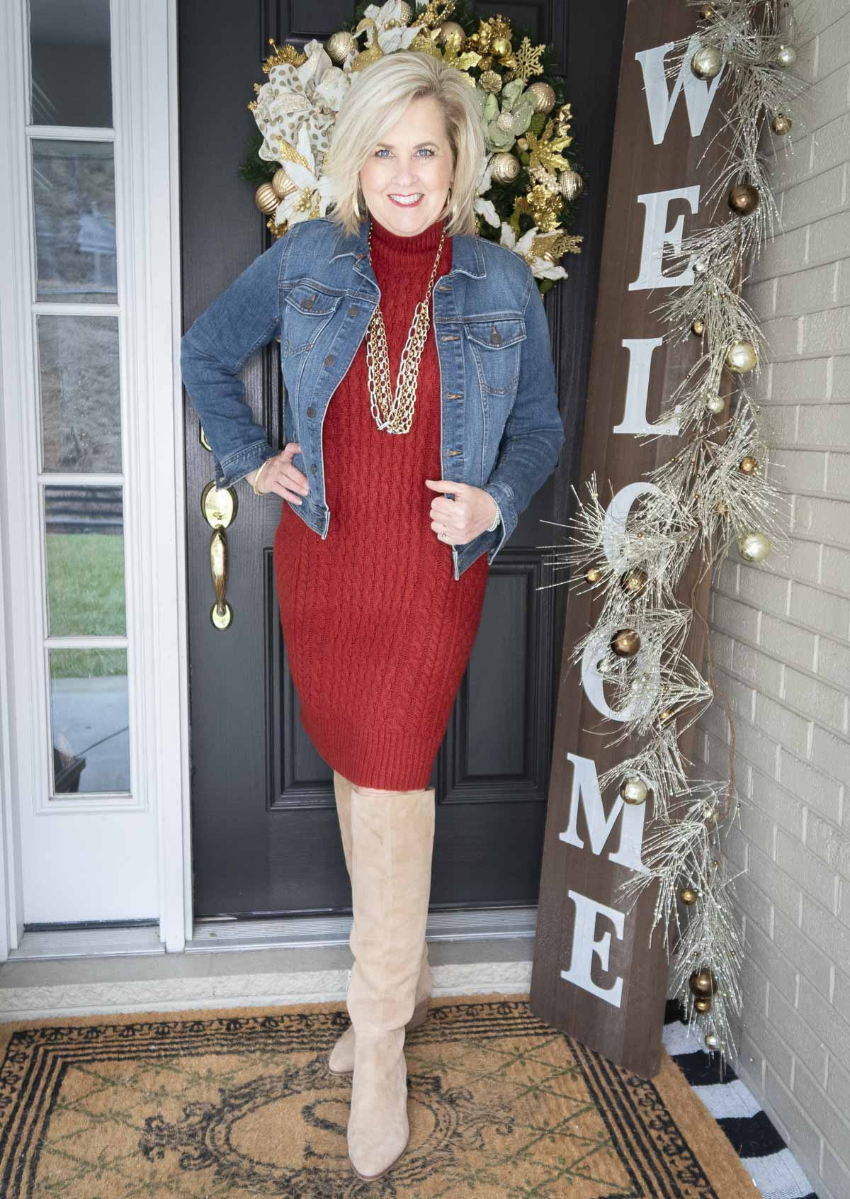 Fashion Blogger 50 Is Not Old is looking her best in this red sweater dress, denim jacket, and tall boots