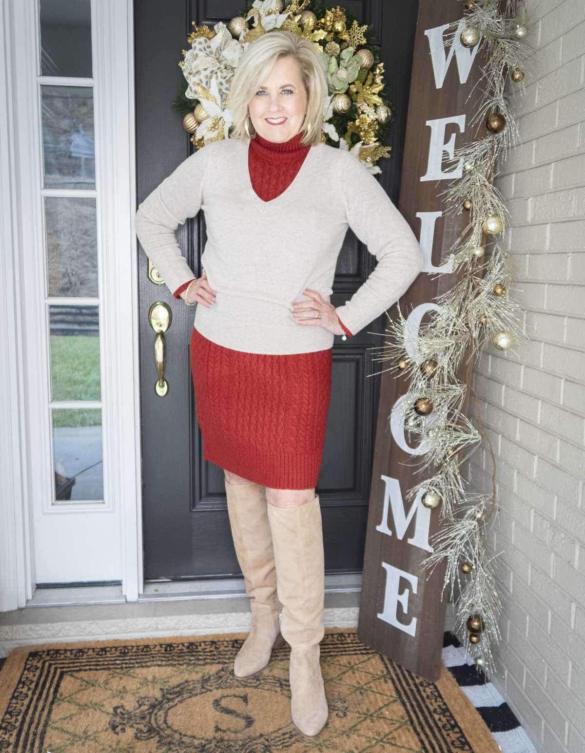 Fashion Blogger 50 Is Not Old is looking her best in this red sweater dress, a oatmeal colored v-neck sweater, and tall boots