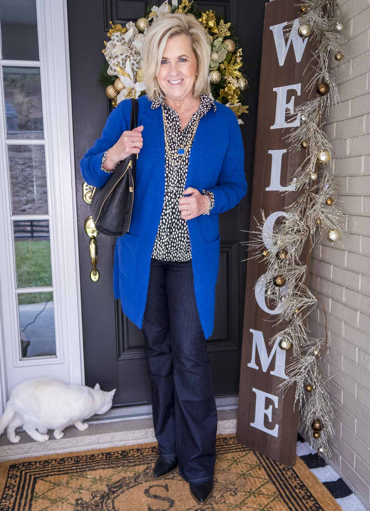 Over 40 Fashion Blogger 50 Is Not Old is wearing a blue cardigan over a button up shirt and dark rinse jeans