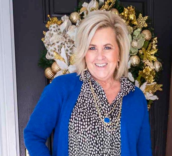 Over 40 Fashion Blogger 50 Is Not Old is wearing a bright blue colored cardigan over a button up shirt with gold jewelry
