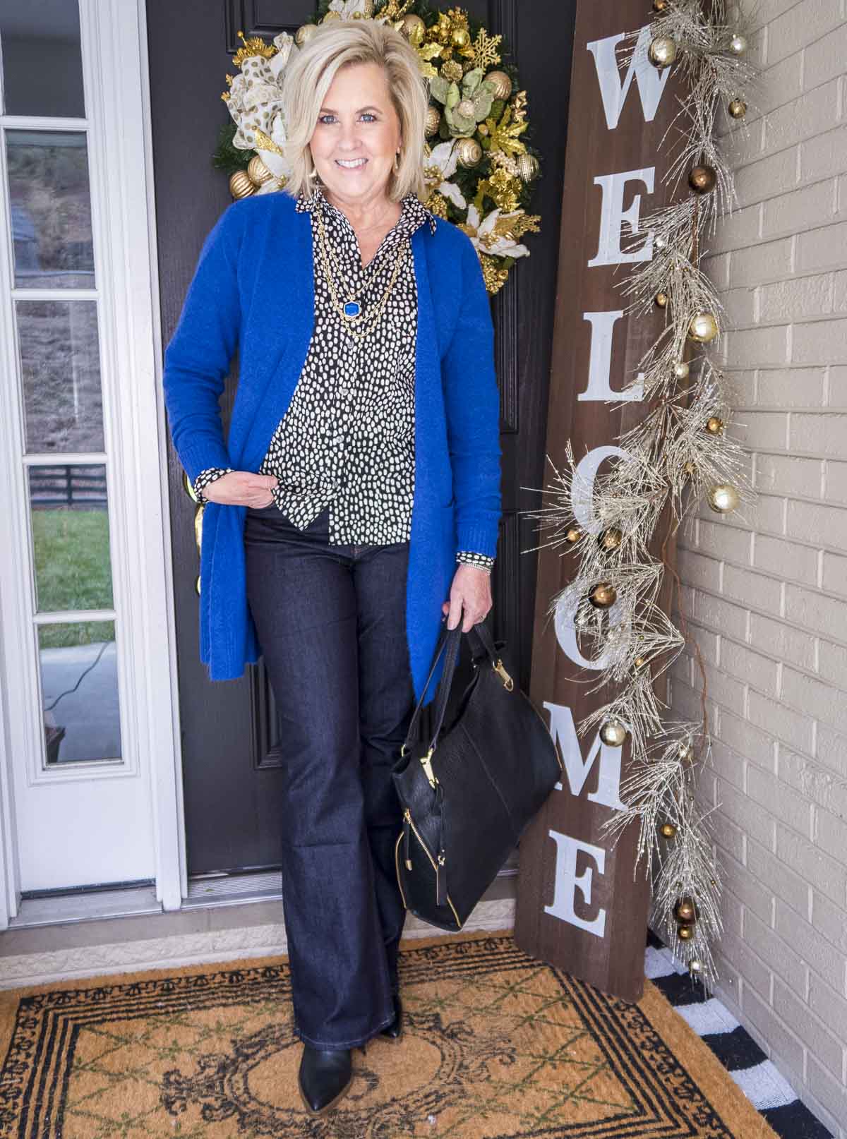 Over 40 Fashion Blogger 50 Is Not Old is wearing a bright colored cardigan over a button up shirt and dark rinse jeans