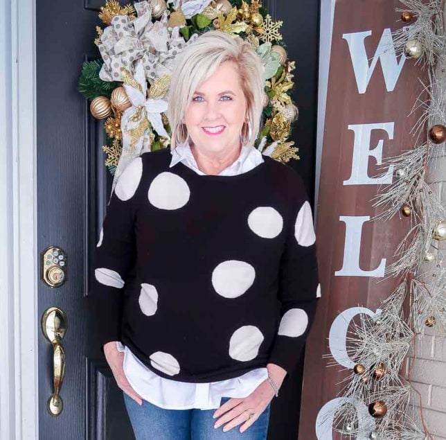 Fashion Blogger 50 Is Not Old is wearing a black and white polka dot sweater with a classic white button up shirt