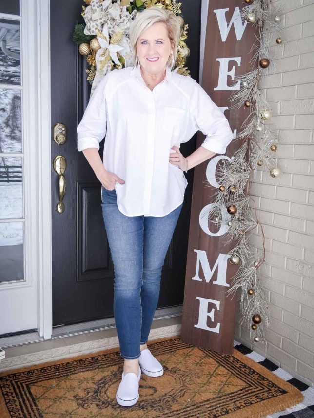 Fashion Blogger 50 Is Not Old is wearing a classic white button up shirt, skinny jeans in a medium wash, and white sneakers