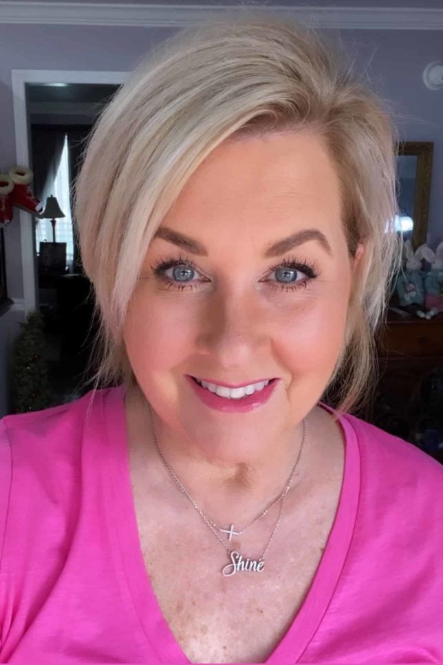 Fashion Blogger 50 Is Not Old is wearing a bright pink v-neck tee shirt and wearing silver jewelry