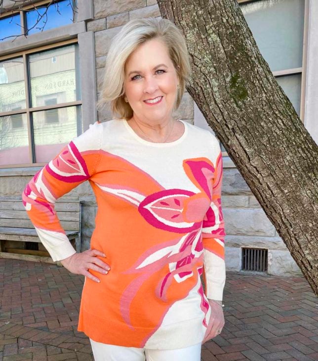 Fashion Blogger 50 Is Not Old is wearing a beautiful tunic sweater with a large floral print