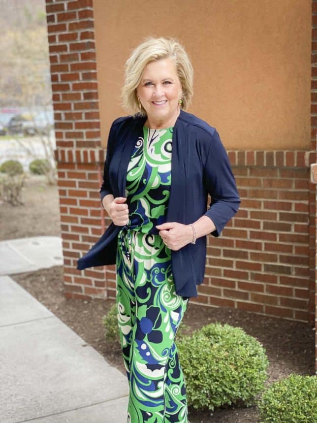 Fashion Blogger 50 Is Not Old is wearing a wrinkle resistant scroll printed jumpsuit with a navy jacket