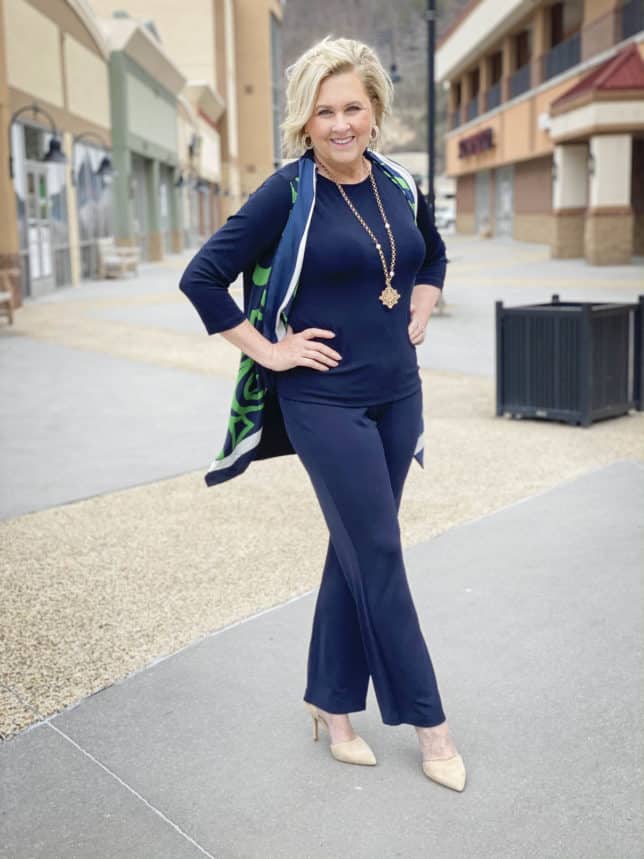 Fashion Blogger 50 Is Not Old is wearing a navy monochromatic navy outfit with a scarf cardigan, neutral shoes, and gold jewelry