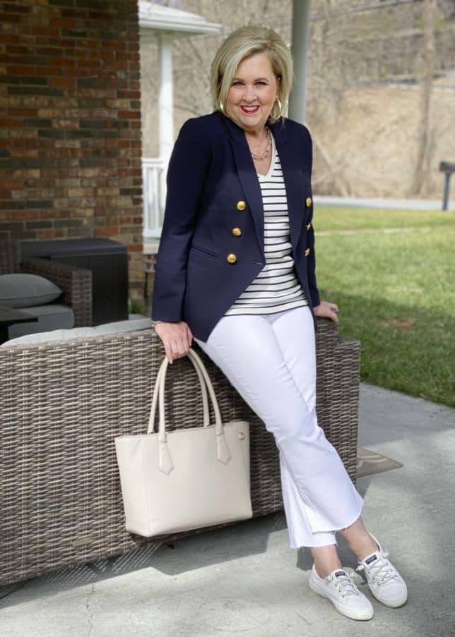 Fashion Blogger 50 Is Not Old dressed like a french woman in stripes, a navy blazer, white jeans, and sneakers