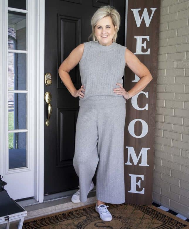 Fashion Blogger 50 Is Not Old has her hands on her hips while wearing a gray cropped loungewear set from Target with Sperry sneakers