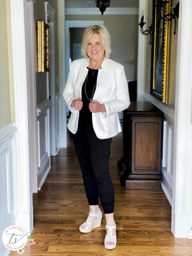 Fashion Blogger 50 Is Not Old is wearing a black jumpsuit and a white notched collar blazer from Gibsonlook