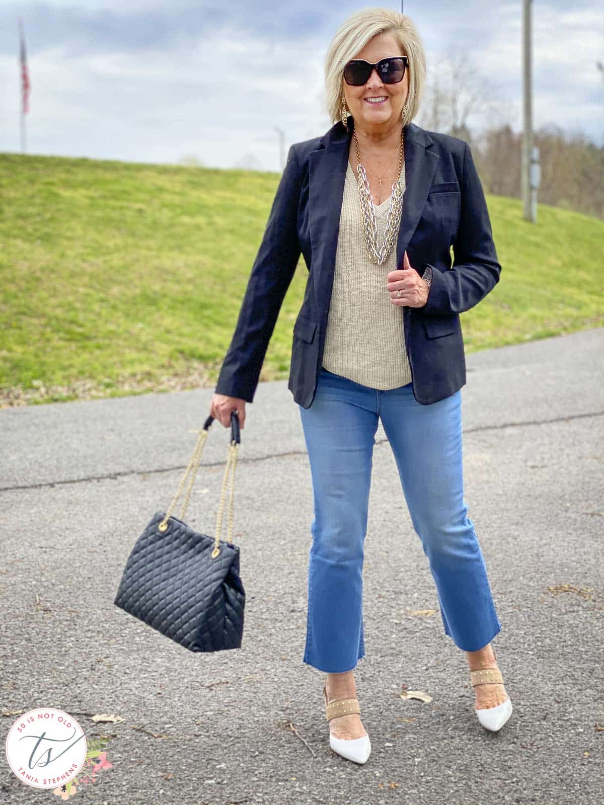Over 40 Fashion Blogger, Tania Stephens, is wearing a linen tank and a black blazer with her cropped flare fall jeans