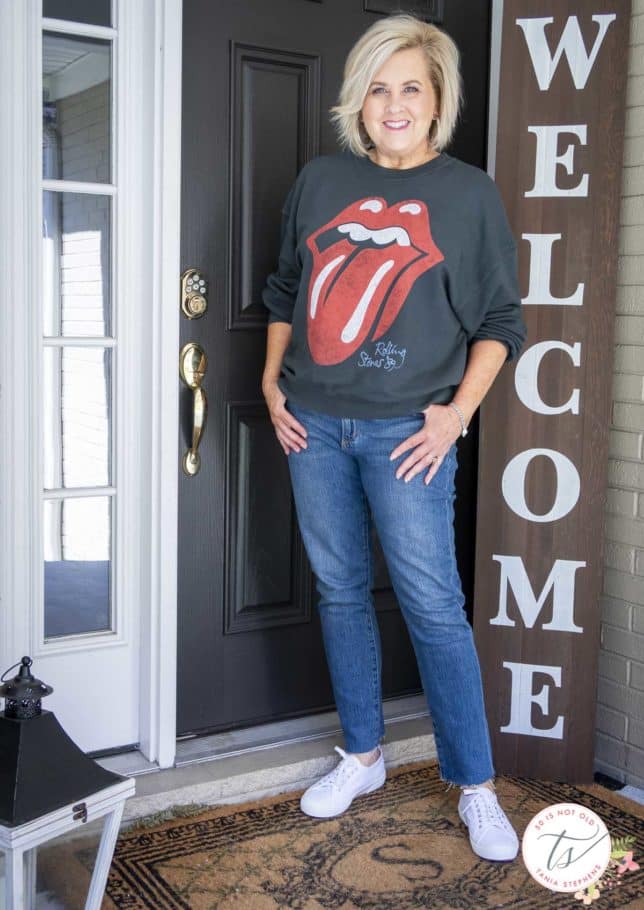 Fashion Blogger 50 Is Not Old is wearing a black Rolling Stones tongue sweatshirt and a pair of jeans
