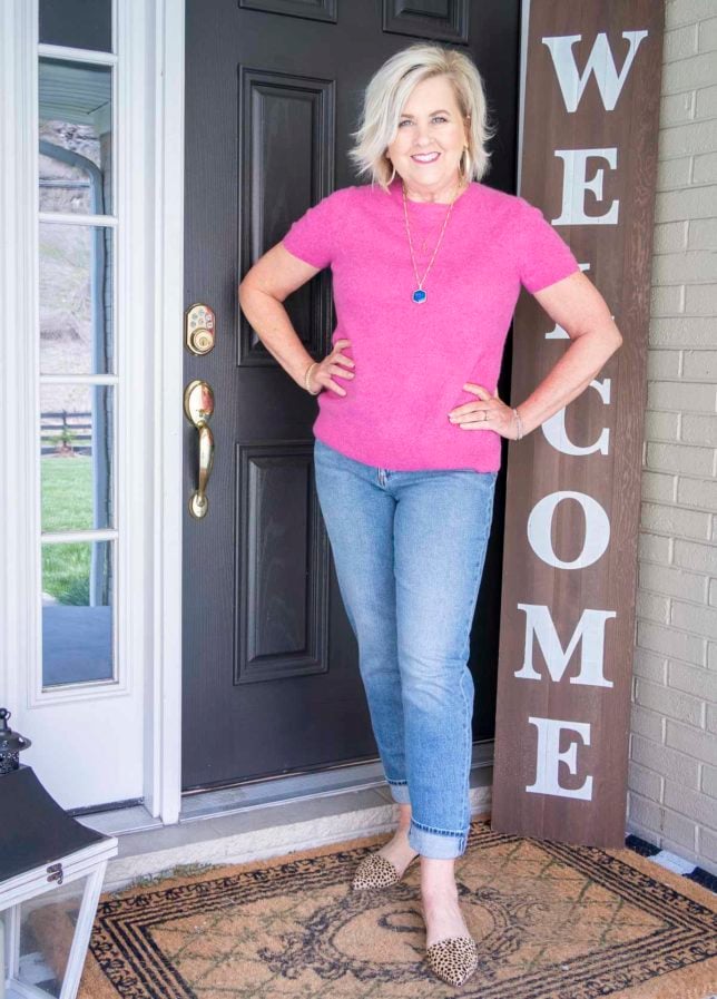 Fashion Blogger 50 Is Not Old is wearing an age appropriate cashmere sweater tee in rose pink, a pair of straight leg jeans, and leopard print flats