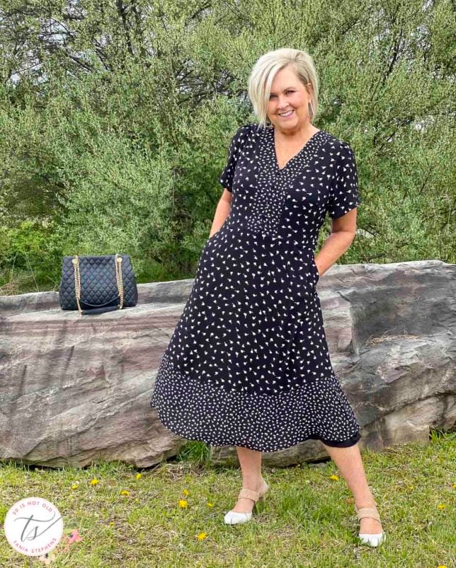 Fashion Blogger 50 Is Not Old is wearing a black and white dress with Rockport heels and a black quilted bag